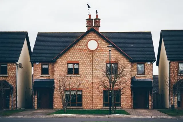 A row of brick houses with a clock on the front.